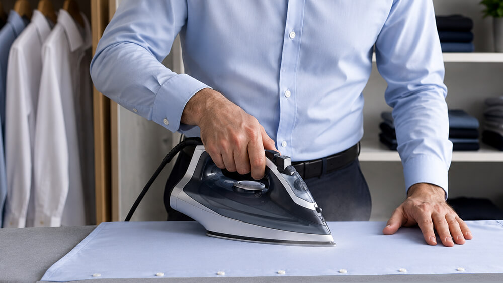 Men's shirt being ironed on an ironing board